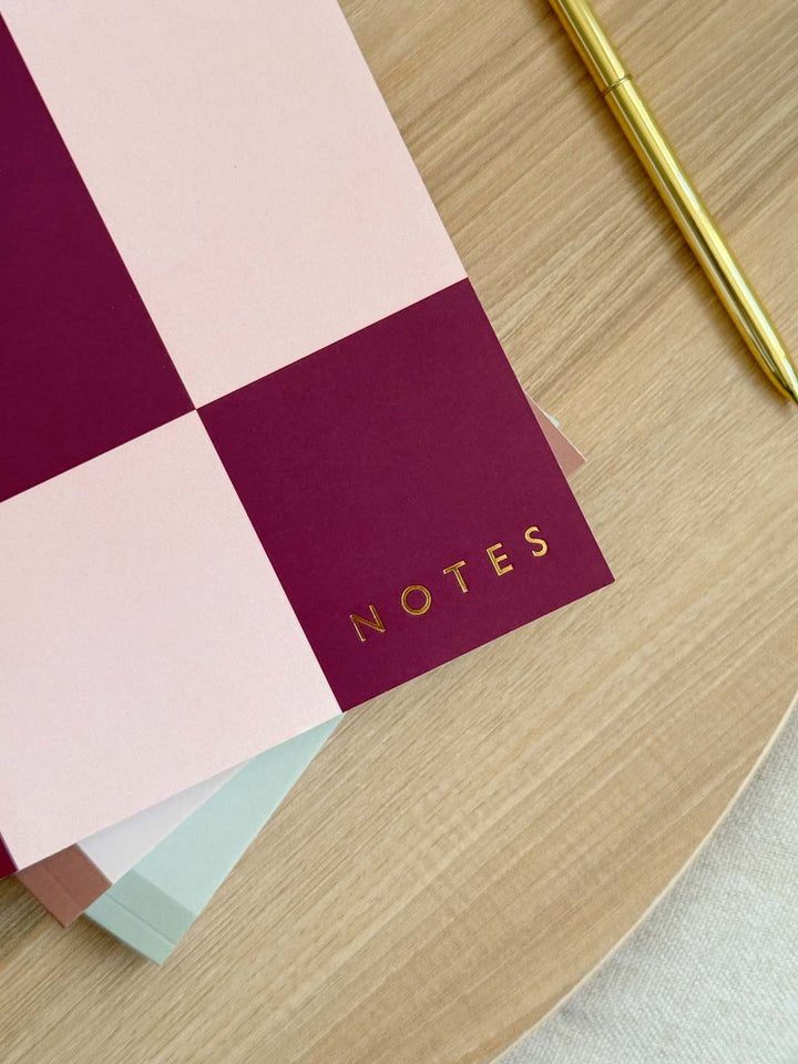 close up of gold foil embossed text on the cover of an A5 softcover notebook.