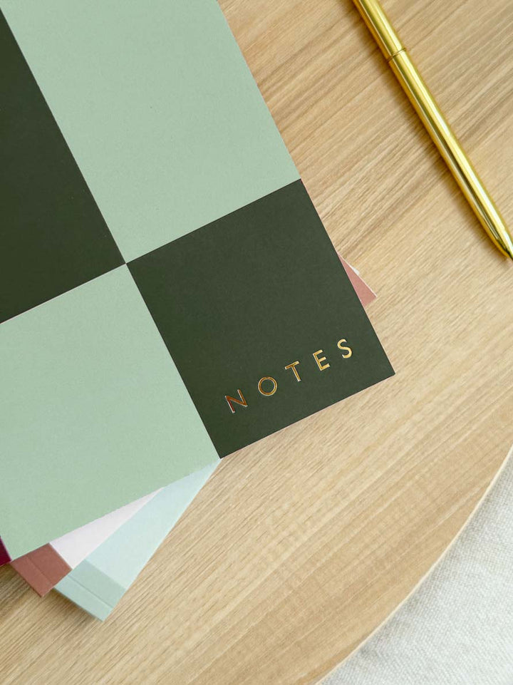checkered green notebook cover with close up of gold foiled "NOTES" stamped in the bottom corner