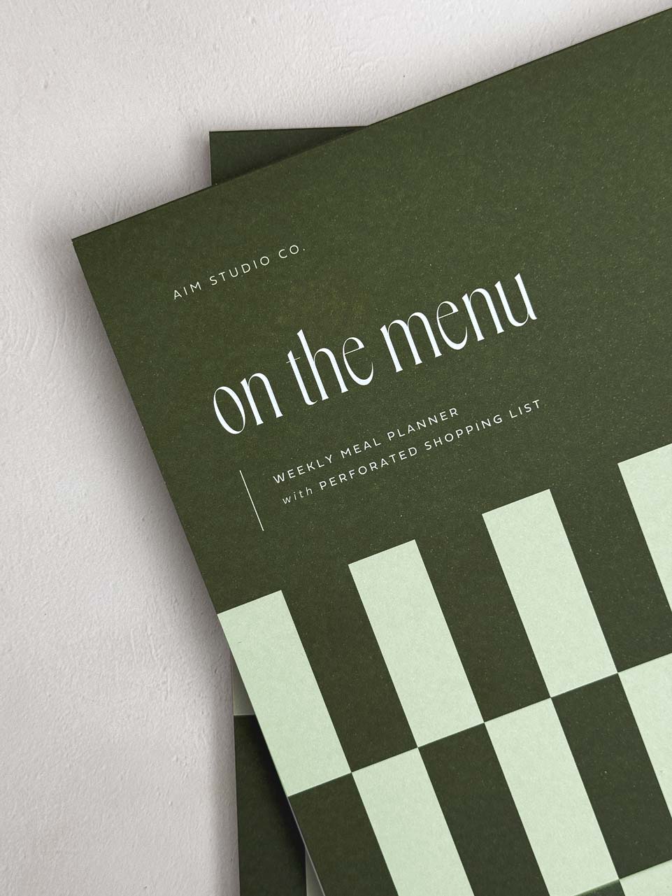 Green meal planner notepad with 'on the menu' text and green checkered design.