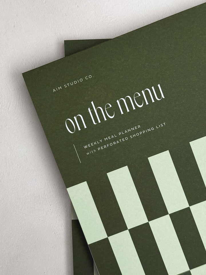 Green meal planner notepad with 'on the menu' text and green checkered design.