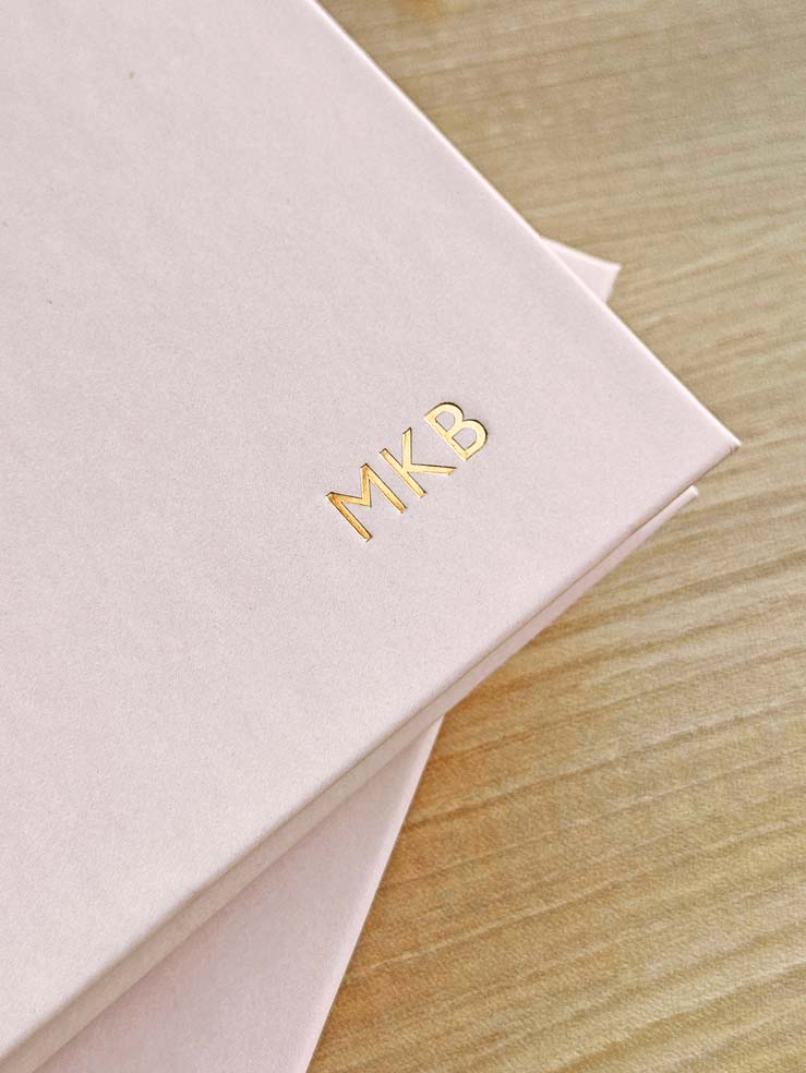 close up of personalised initials embossed in gold foil on hardback pale pink diary cover