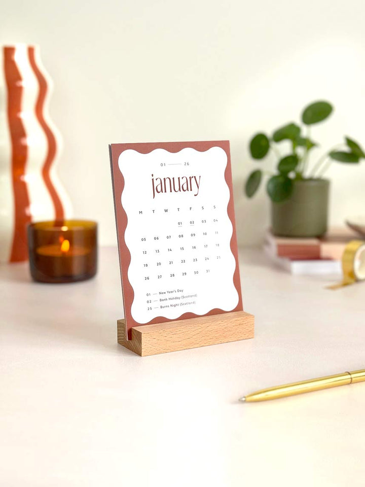 small desktop calendar showing month view of january 2026 within an aesthetic office desk environment