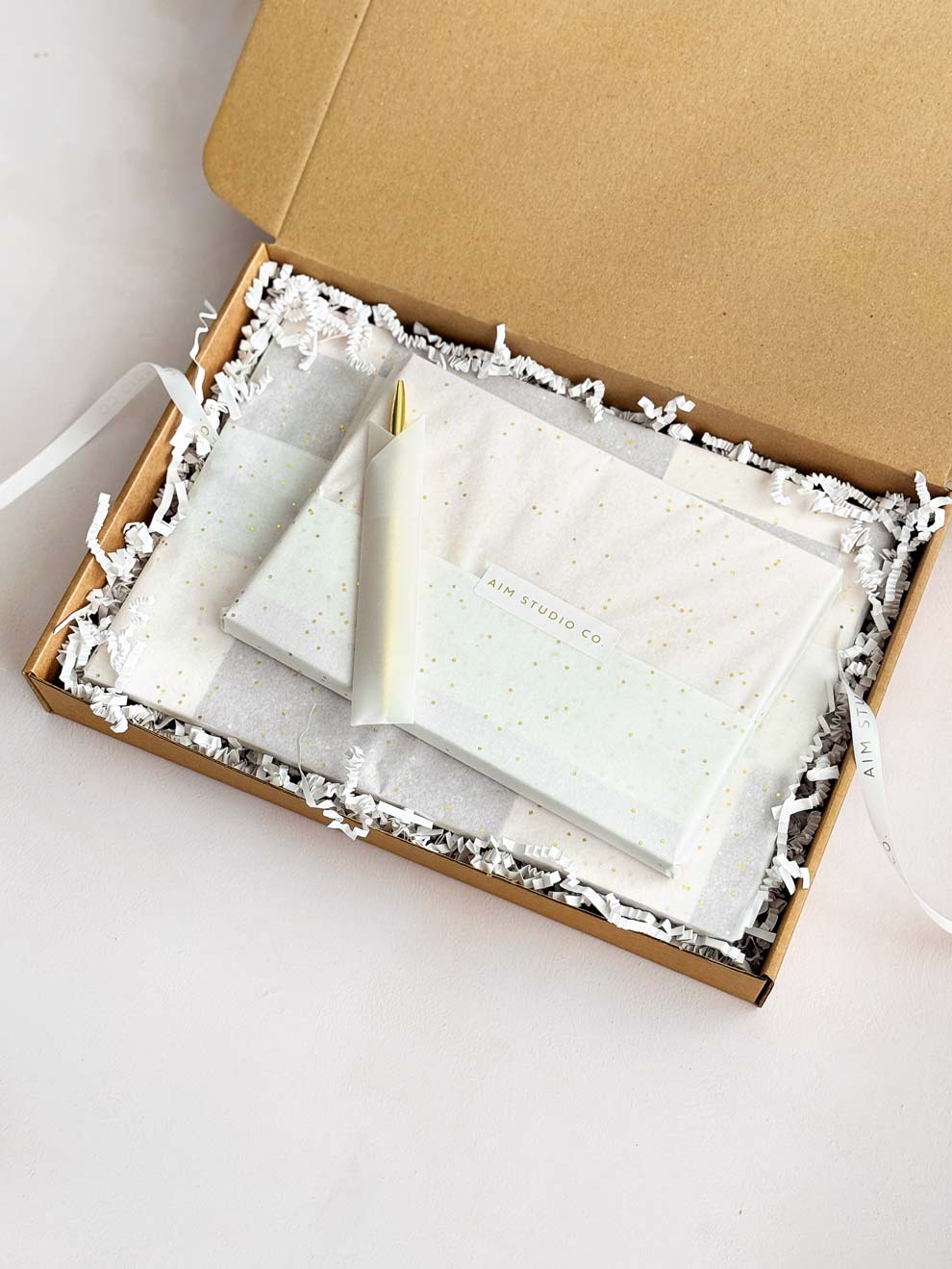 gift wrapped stationery inside box with AIM Studio Co ribbon