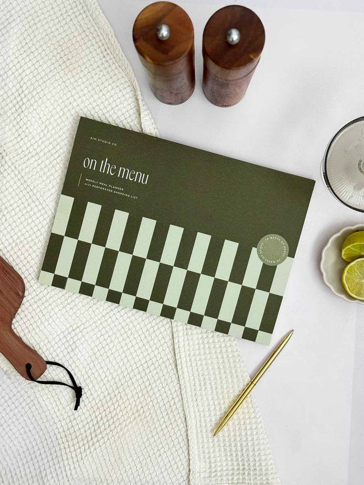 A4 food tracker notepad with "on the menu" title on a green checkerboard cover.