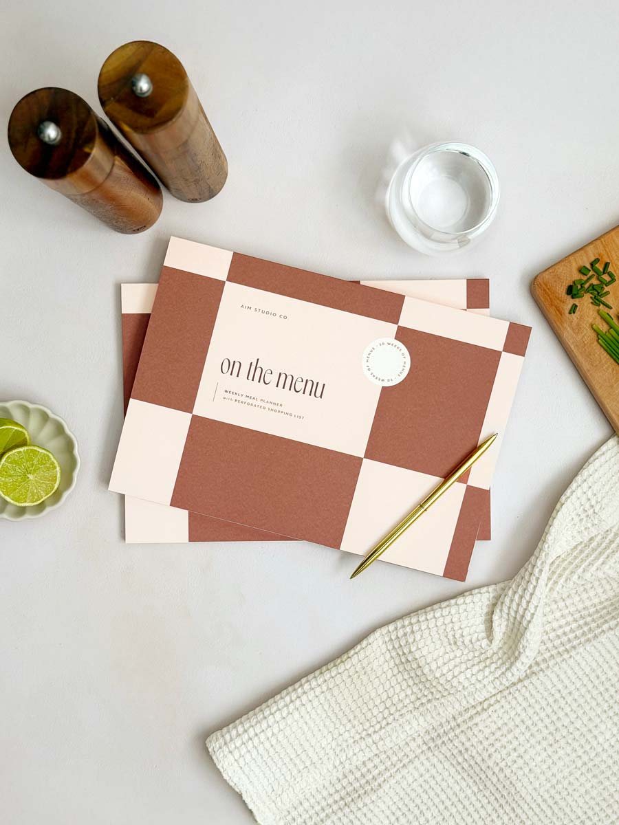 cover of A4 menu notepad with bold checkered design in brown with "on the menu" text on the front