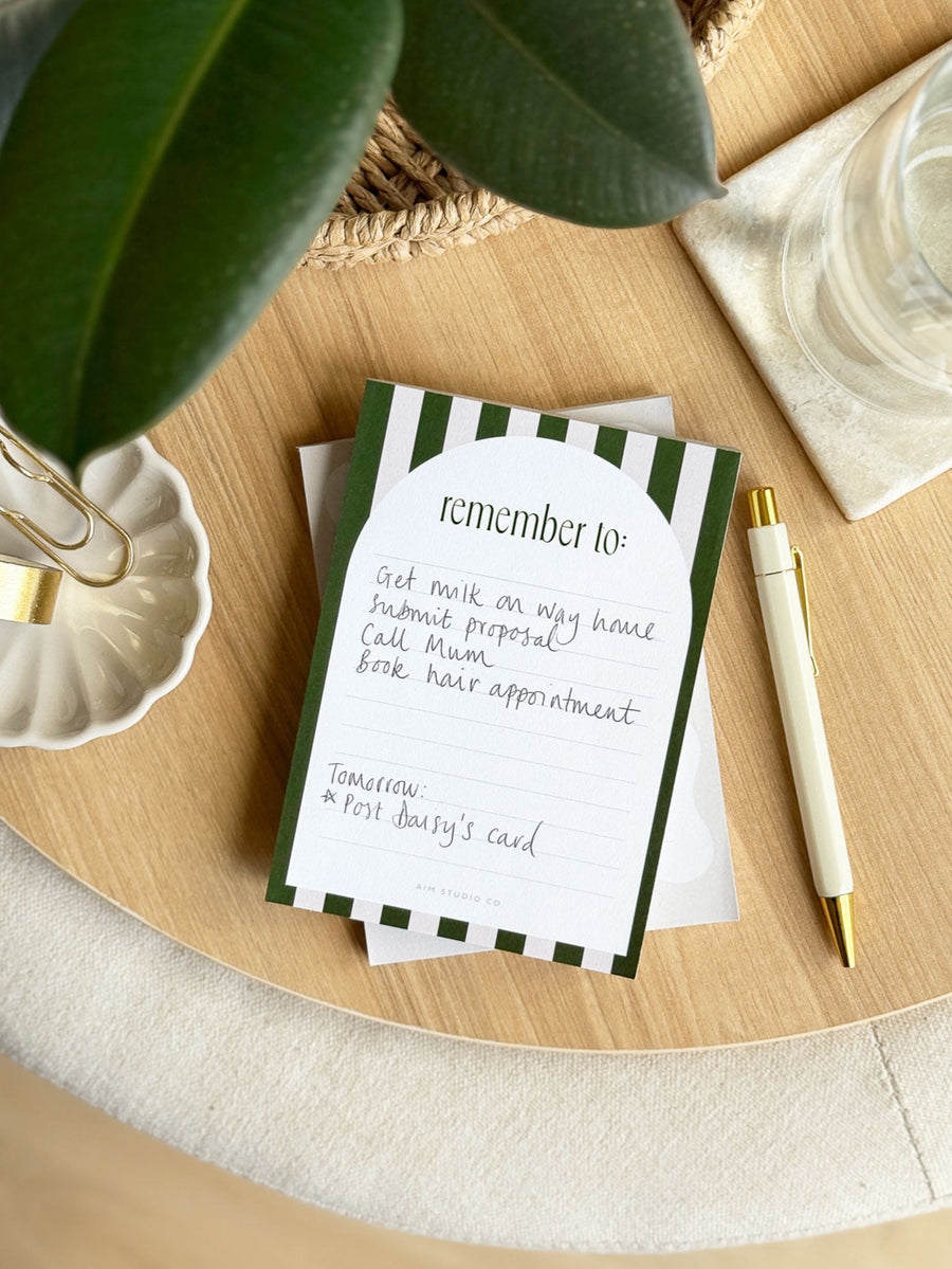 small notepad with lined pages with green and pink stipe design and tear off paper