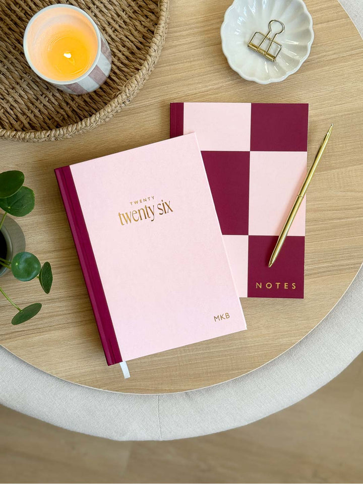 matching 2026 pink hardback diary with notebook and gold pen on office desk