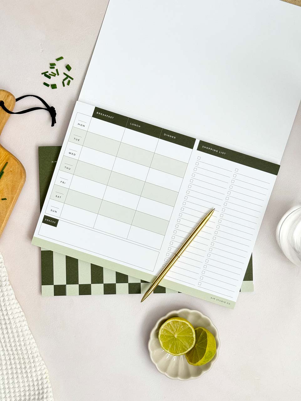 open planner showing weekly menu planner with shopping list on an A4 page with tear-off sheets.