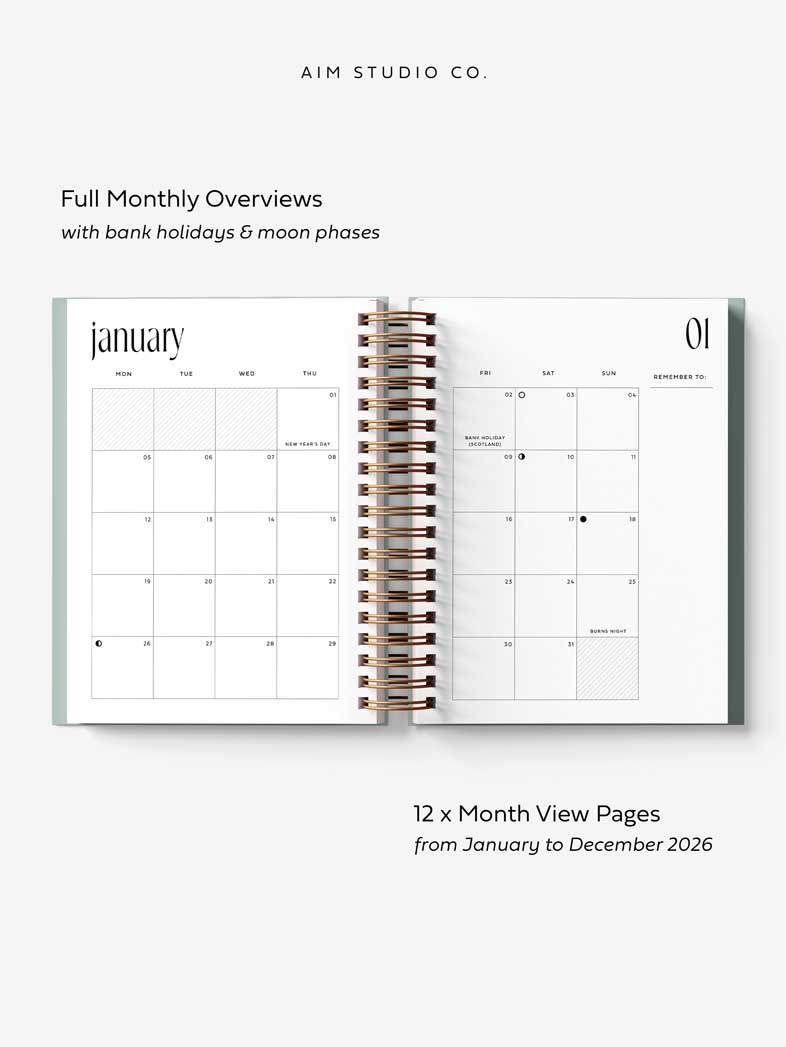 Open A5 hardback spiral-bound planner showing monthly calendar pages with text about features and layout.