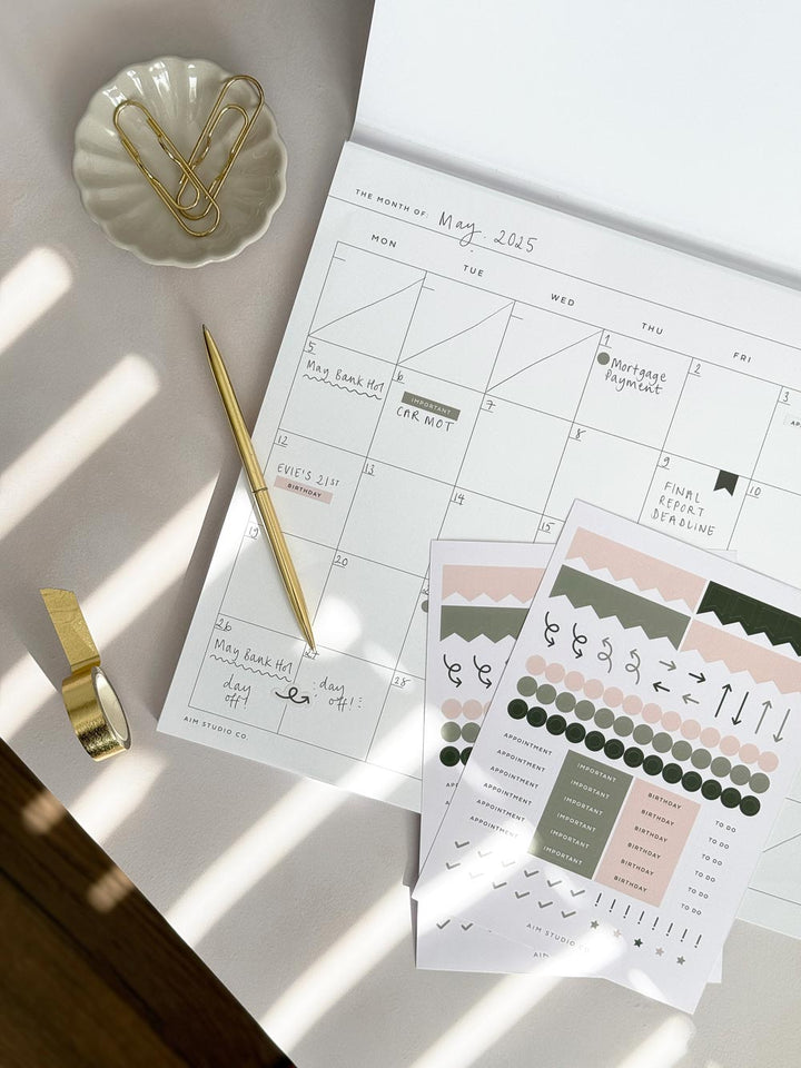 undated monthly planner grid with planner sticker sheets and gold stationery accessories