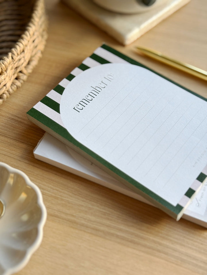 small notepad on a desk surrounded by aesthetic desk accessories for the office and back to school