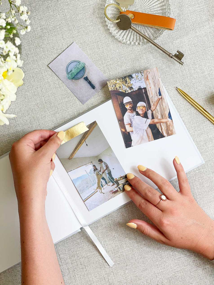 Adding photographs into scrapbook for couples building their new home or house renovation project journal