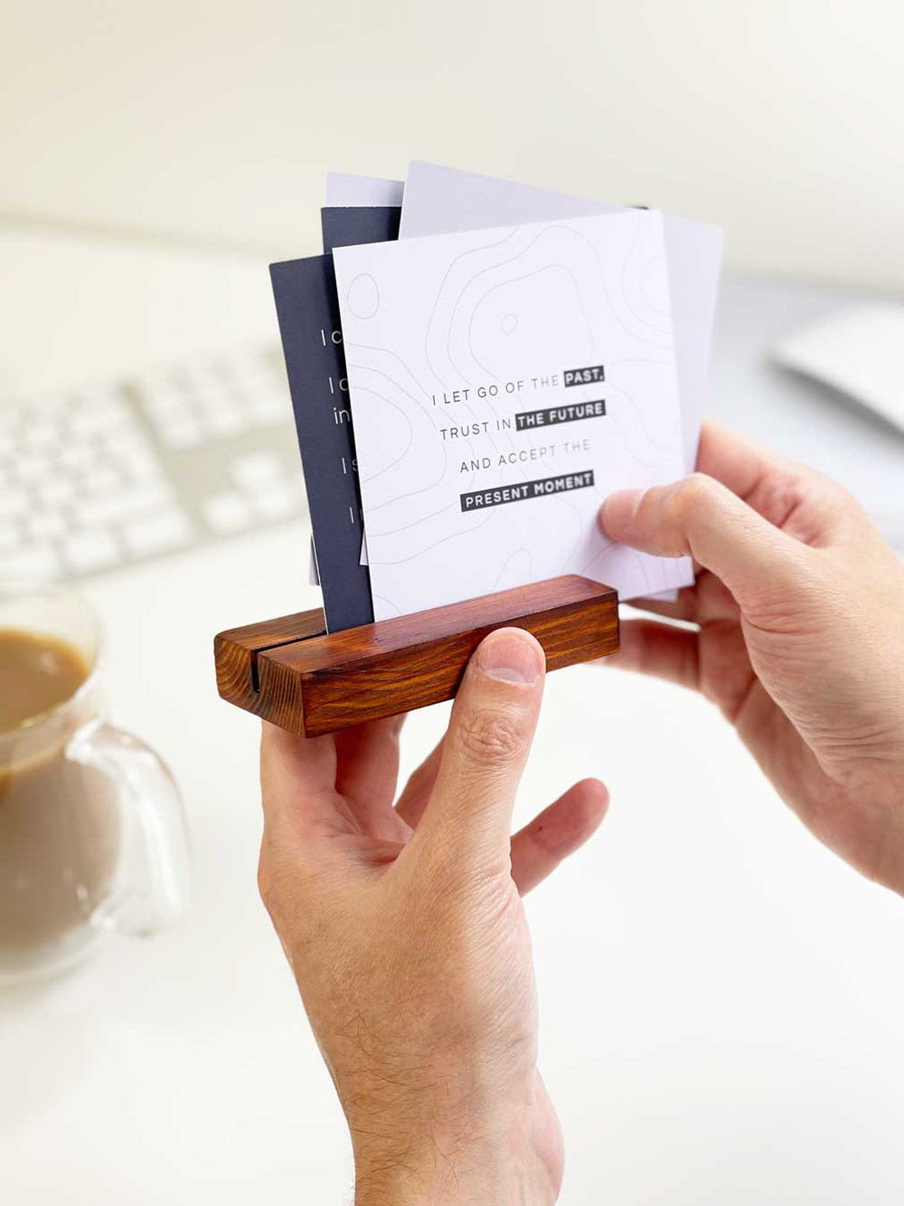 set of positive affirmation cards held in dark wooden block as accessories for a mens desk