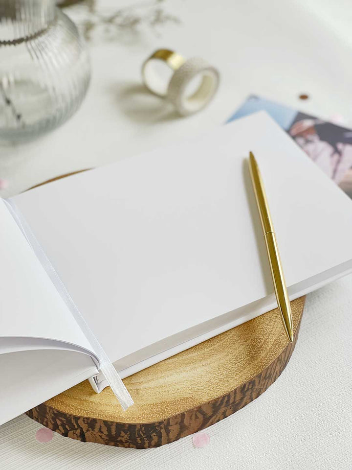inside scrapbook pages of a personalised adventure memory book showing plain pages with a gold pen resting on the scrapbook
