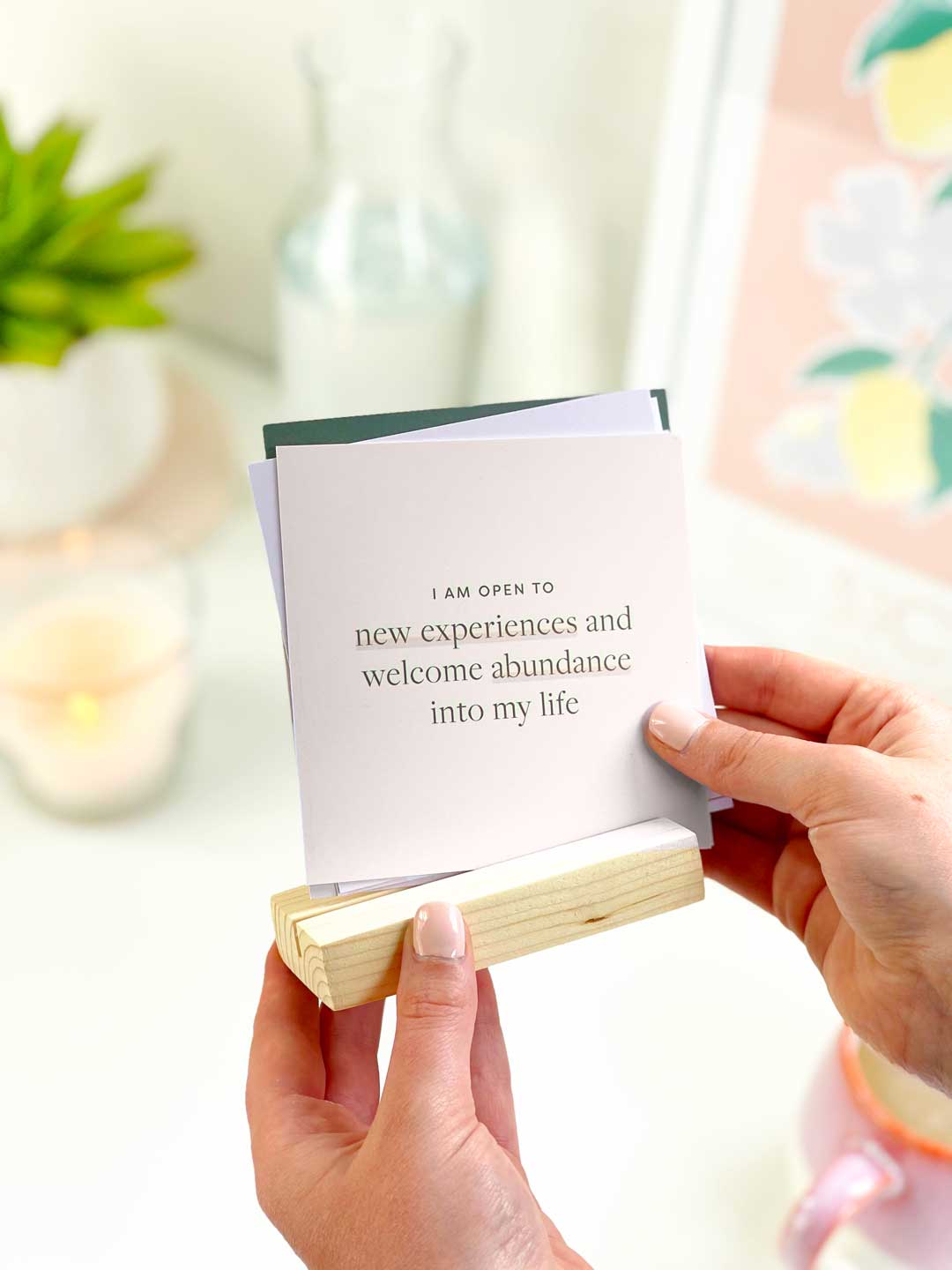 holding a set of positive affirmation cards with pine wood holder to display in the home or on an aesthetic office desk