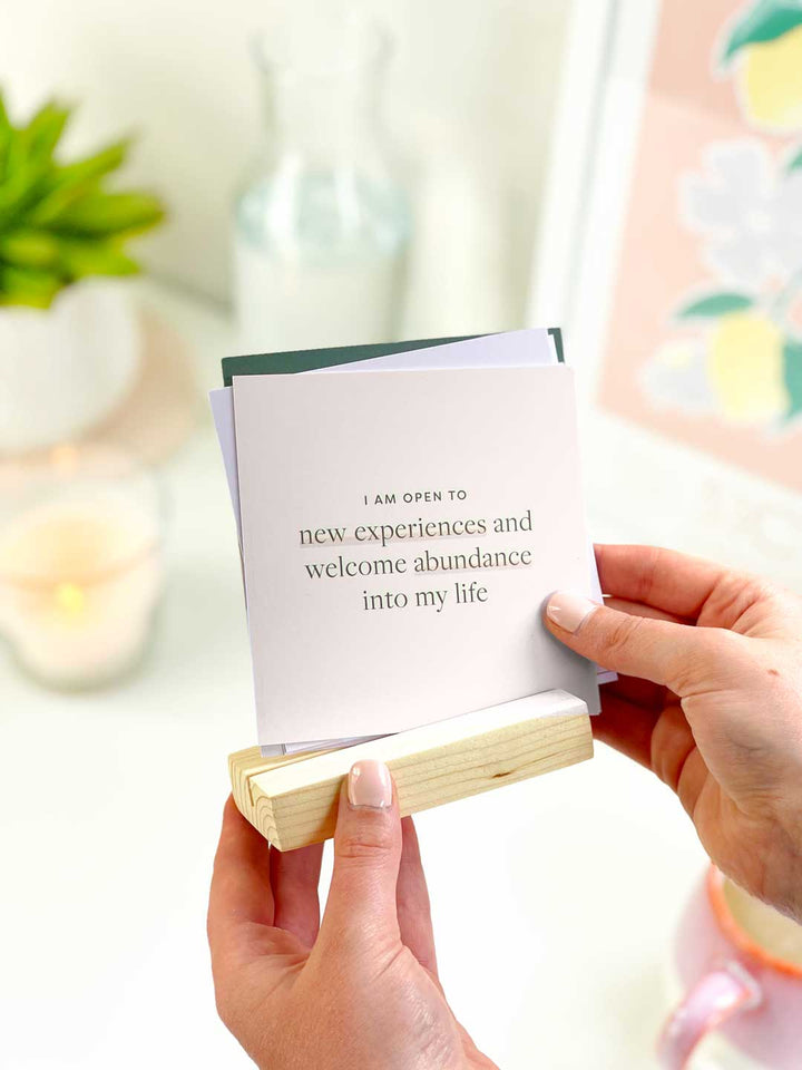 holding a set of positive affirmation cards with pine wood holder to display in the home or on an aesthetic office desk