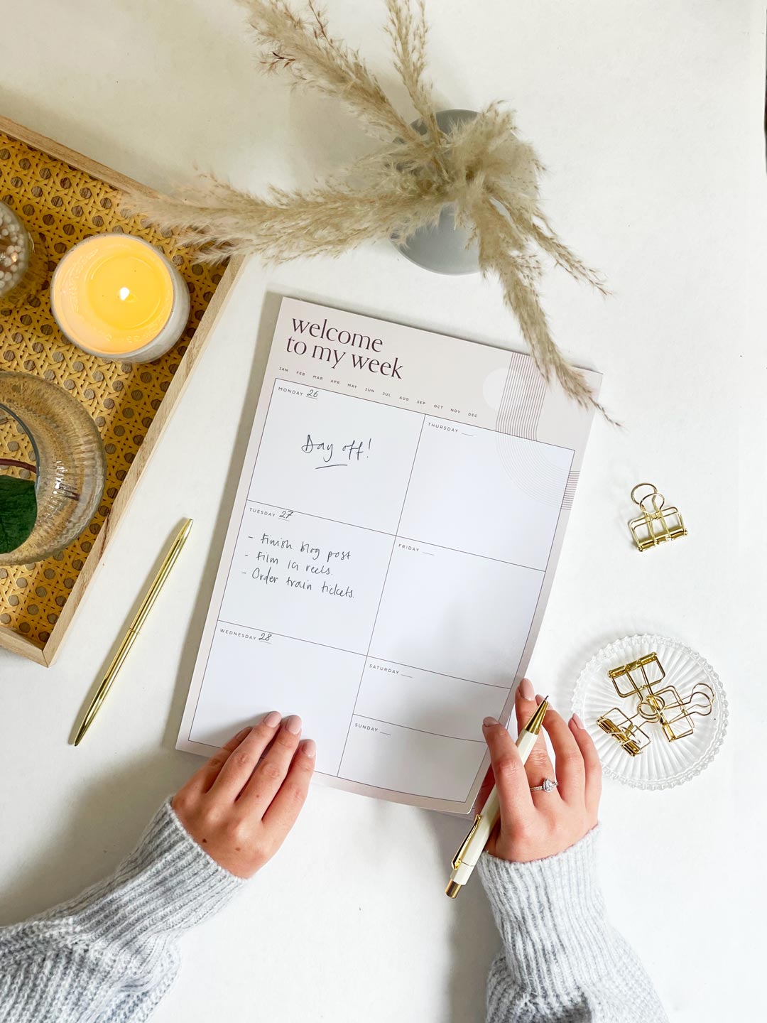 woman writing plans on large A4 desk planner pad showing week to view