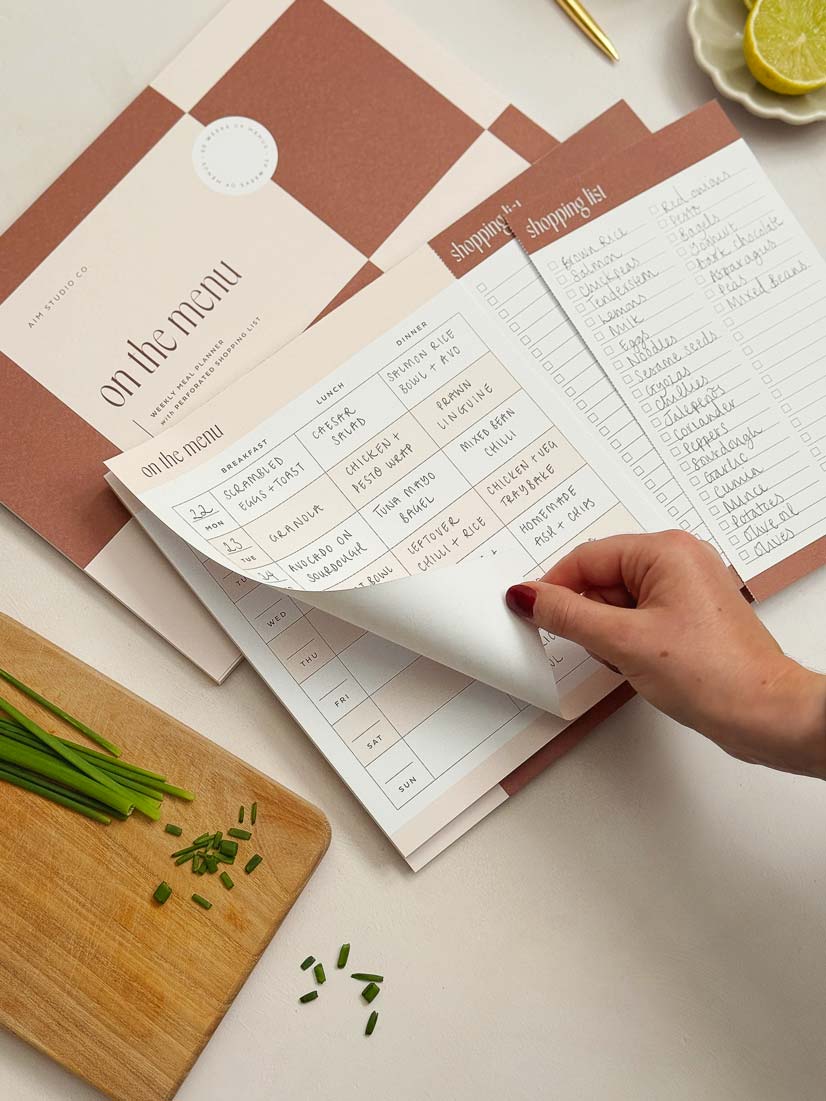 tear-off notepad page showing weekly food menu and grocery list.