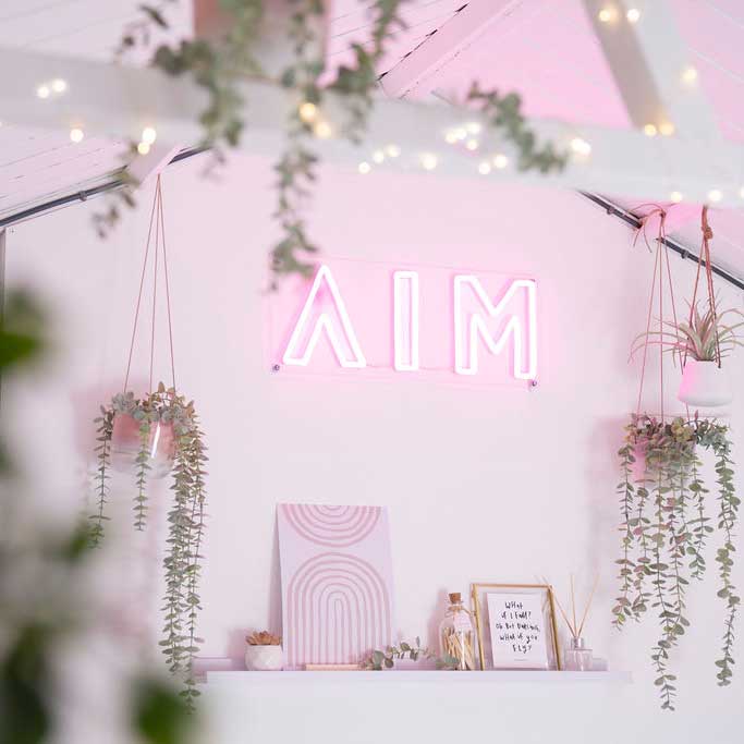 AIM Studio Co logo sign in office with pink aesthetic