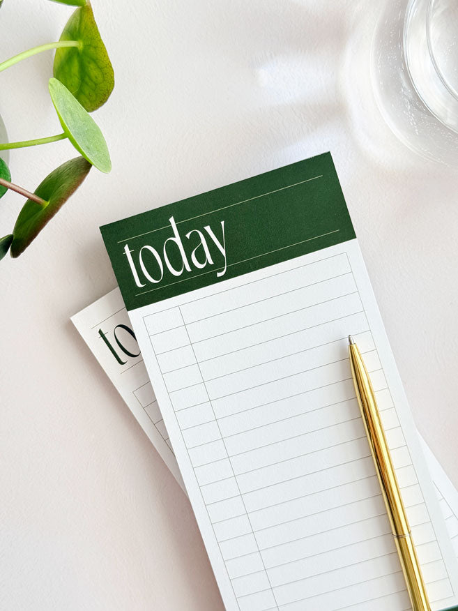 Notepad with 'today' heading and a pen on a light surface and minimal planner grid for time blocking and to do list