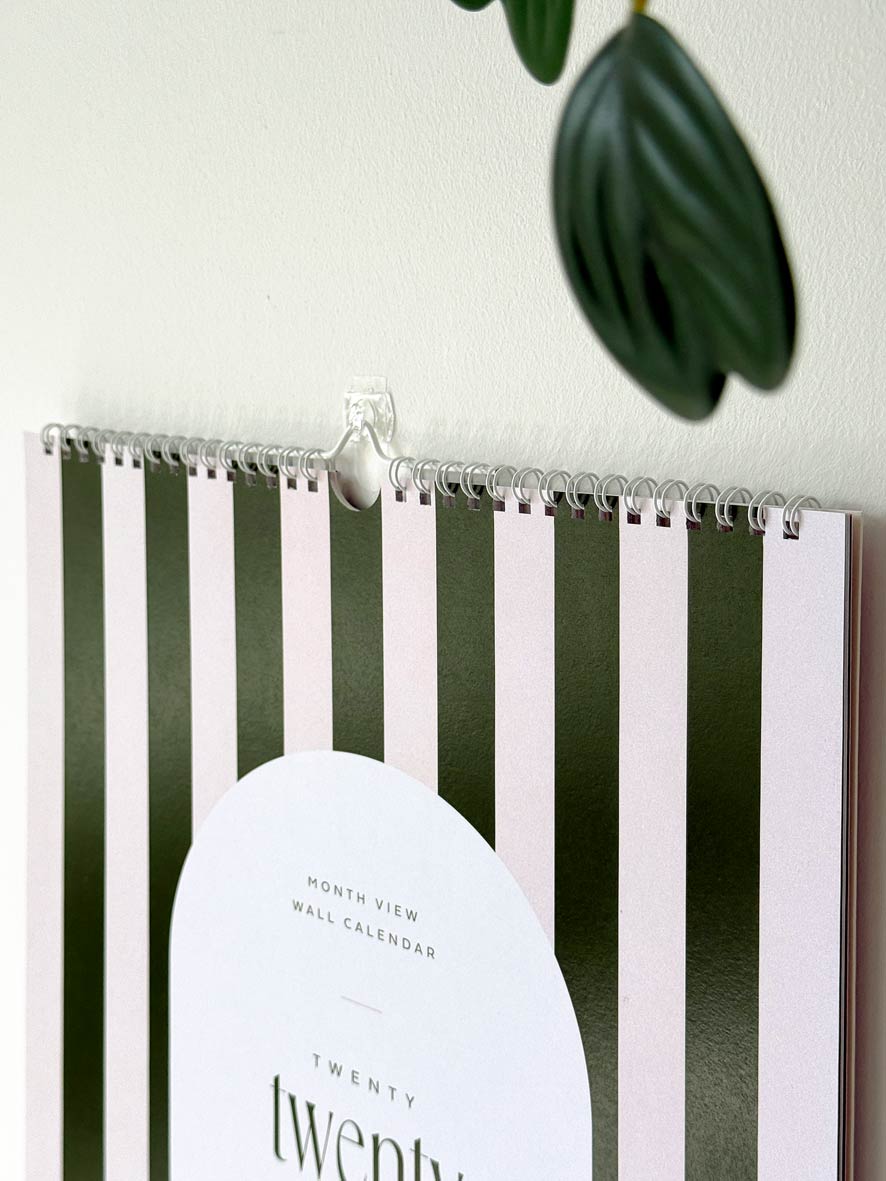Striped wall calendar cover with white binding and hanging loop to display on wall of home or office