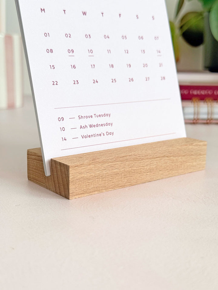 close up of wooden stand holding 2027 calendar cards on a desktop.