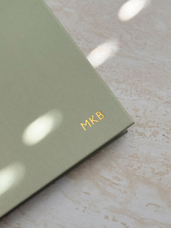 close up of gold foiled personalised initials embossed into the cover of sage green weekly planner by AIM Studio Co.