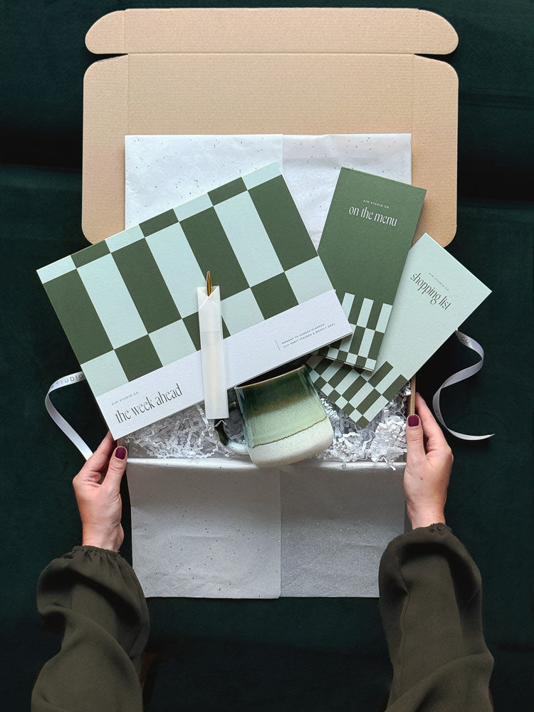 The Home Planning Set: a green stationery bundle with an A4 weekly planner notepad, gold pen and a matching meal planner and shopping list set.