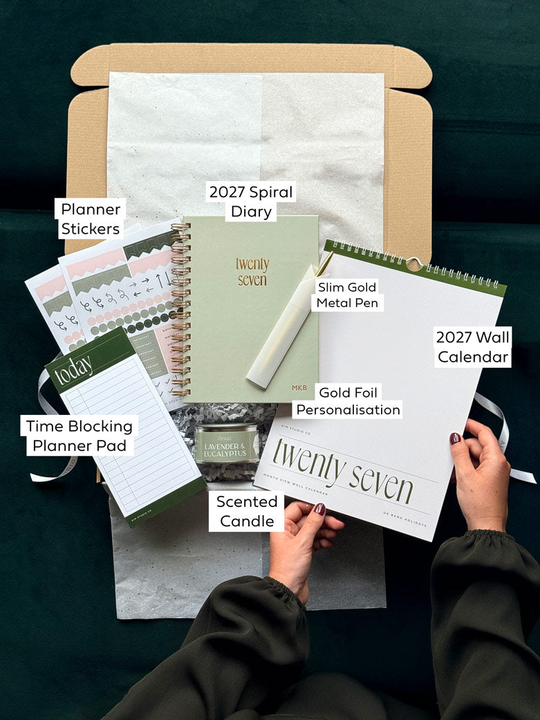 Labelled items inside the Sage Year Ahead Set: personalised 2027 diary, minimalist wall calendar, time blocking planner, planner stickers, gold pen and candle.