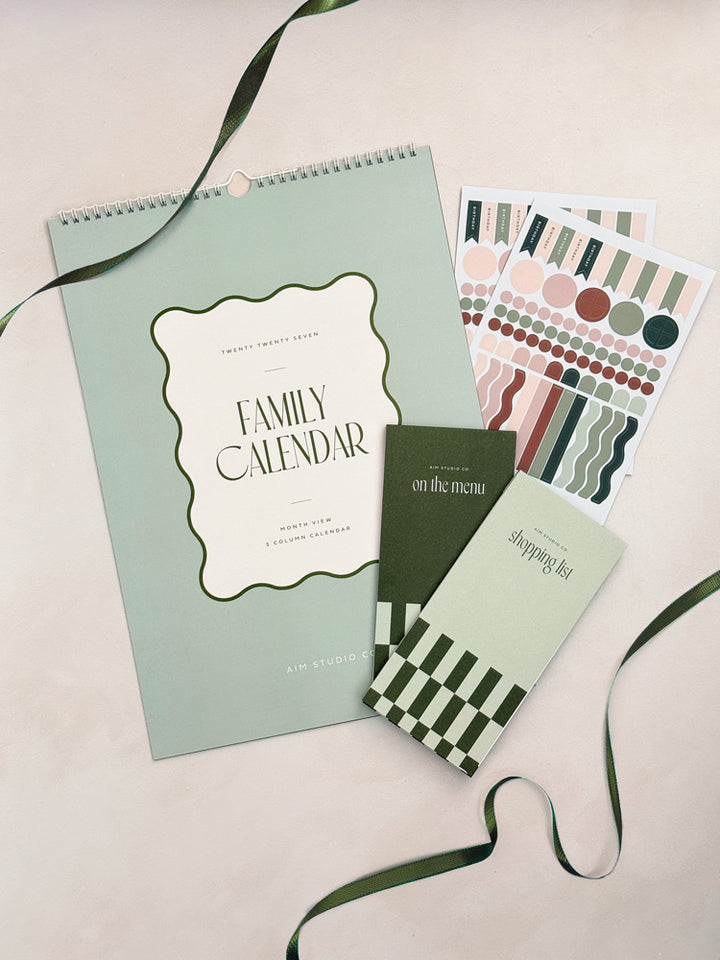 The Family Organiser Set in sage green: a large A3 2027 family wall calendar with planner stickers and a matching green meal planner and shopping list set.