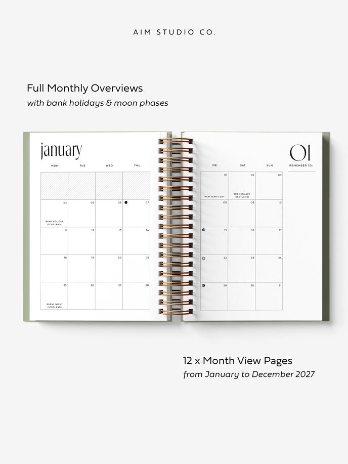 2027 diary with spiral ring binding laid open fully flat to show a monthly calendar overview across two a5 sized pages. The calendar displays moon phases and UK bank holidays, with a &