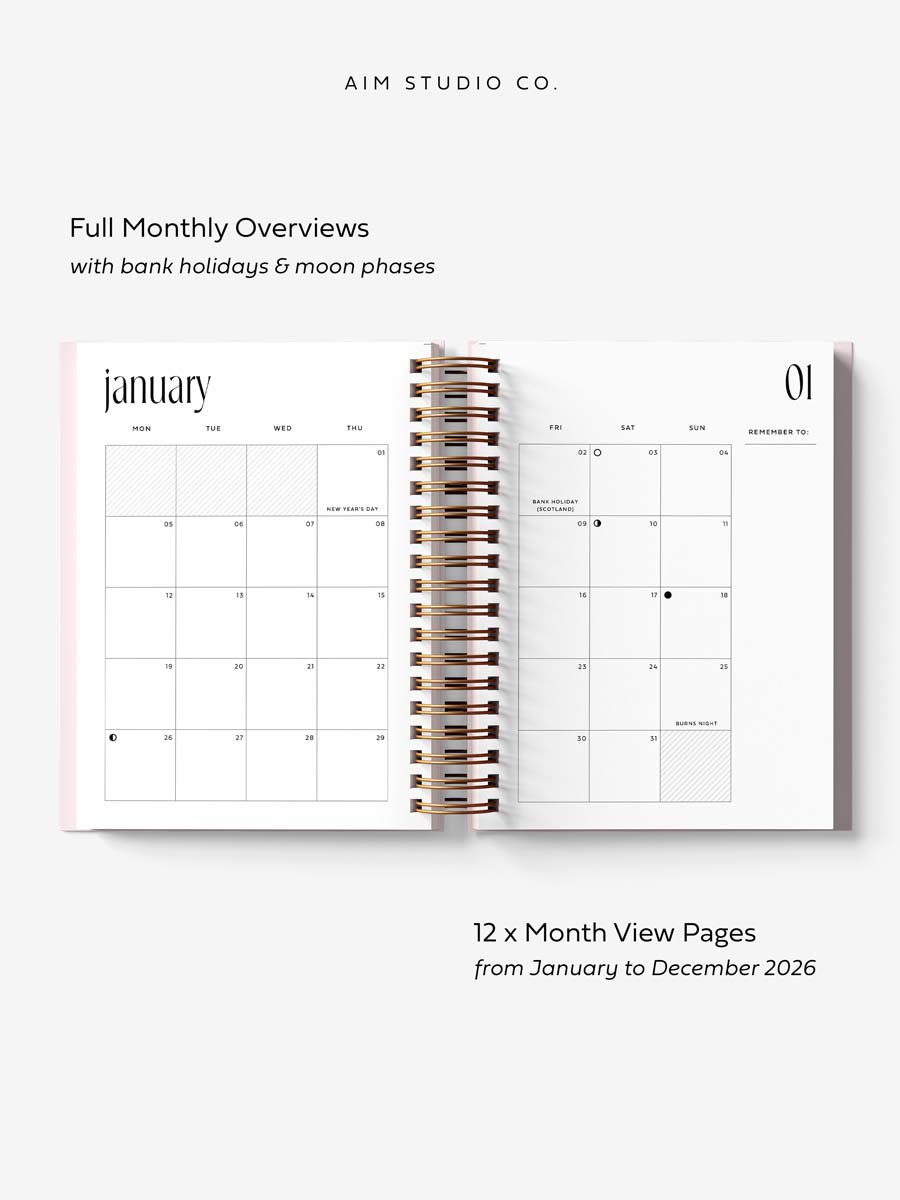 monthly layout inside 2026 diary by aim studio co. the planner is open flat with gold spiral ring-binding and a pink hardback cover