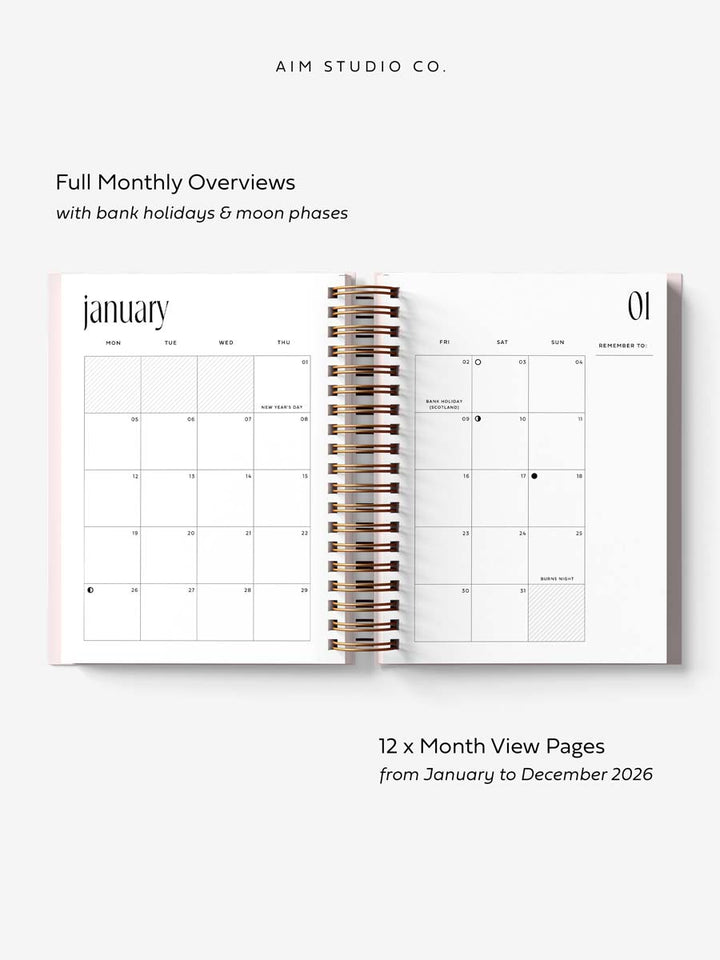 monthly layout inside 2026 diary by aim studio co. the planner is open flat with gold spiral ring-binding and a pink hardback cover