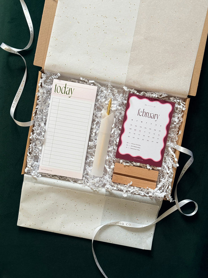 A gift box set with a pale pink lined time blockimg notepad labeled &