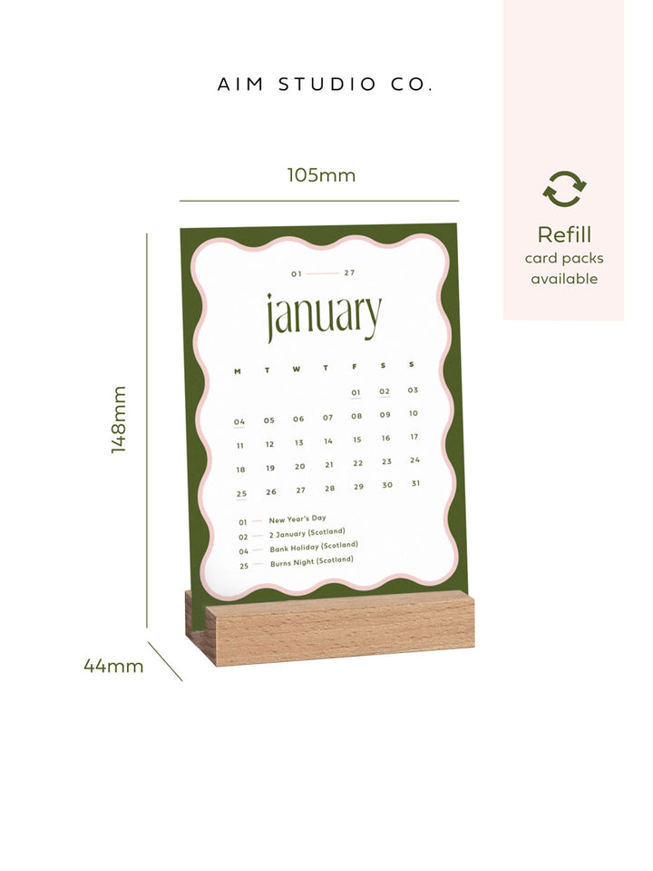 a6 monthly calendar card showing January 2027 held in a wooden block stand with size dimensions reading 105 x 148mm.