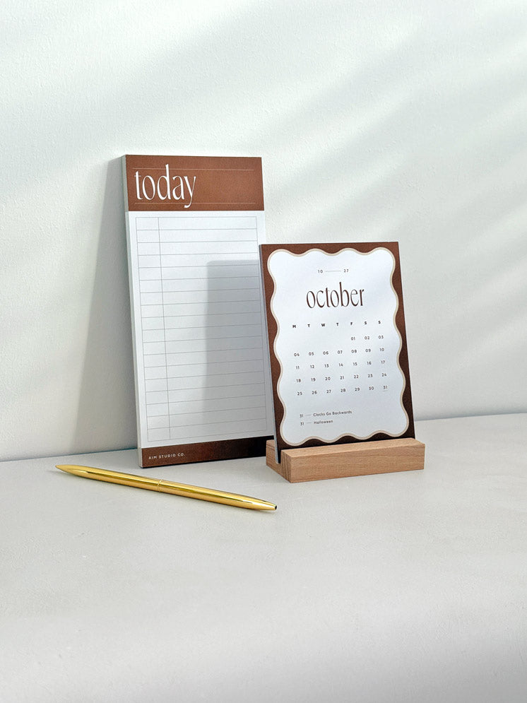 Rust brown time blocking to do list pad and 2027 desk calendar on a sunlit desk, from the Daily Focus Set.