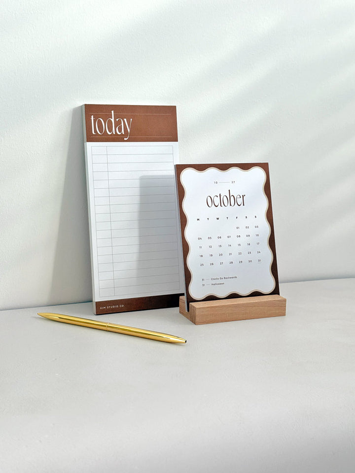 Rust brown time blocking to do list pad and 2027 desk calendar on a sunlit desk, from the Daily Focus Set.