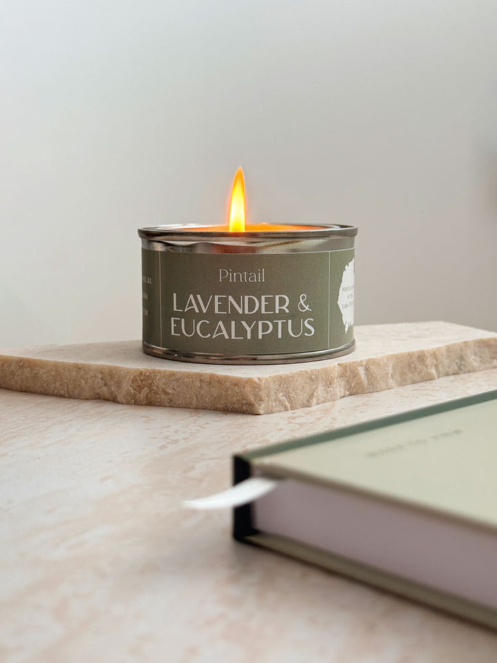Small sage green candle in a mini tin with a lavender and eucalyptus scent, included in AIM Studio Co gift sets.