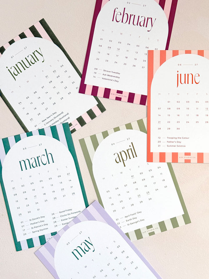 a set of printed monthly calendar cards for 2027 with stripe design for each month. Shows various colourful calendar cards al with UK bank holidays marked.