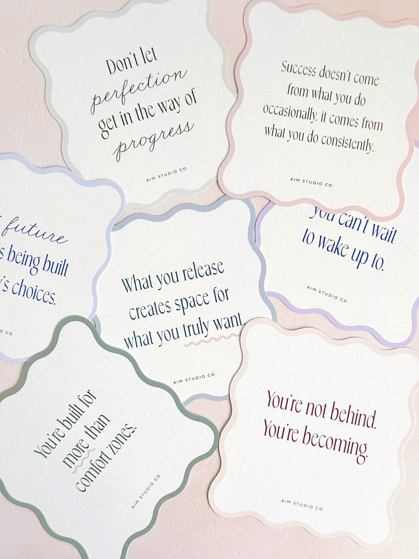 decorative daily quote cards scattered on a surface showing wavy-cut scalloped edges in various pastel shades. Each card displays a positive affirmation in a modern serif font, themed around personal growth, success mindset and confidence.