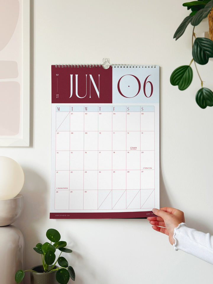 2027 hanging wall calendar showing june 2027 monthly page. It features bold brown and sky blue colour scheme with holidays and UK occassions marked.