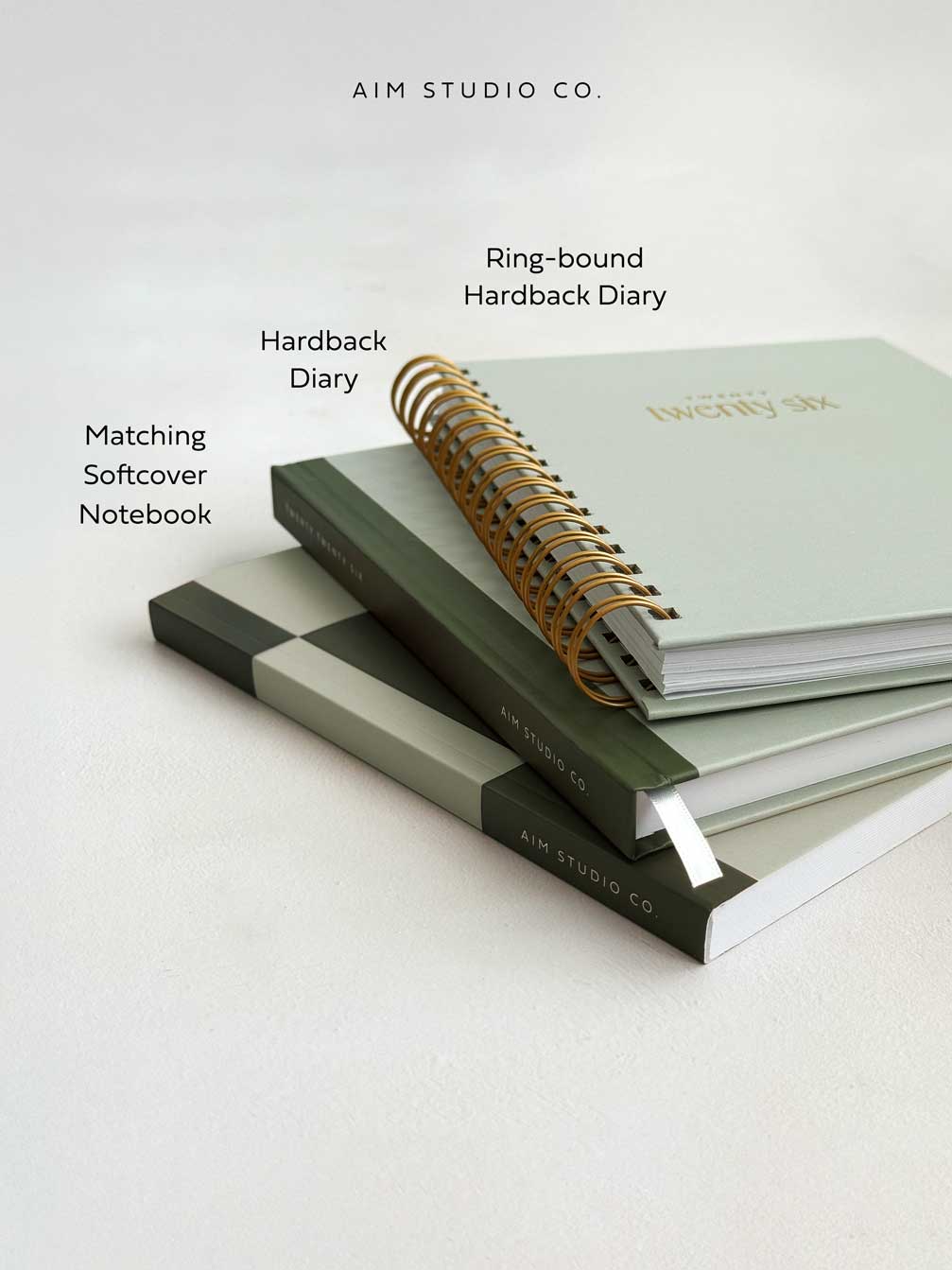 a stack of sage green stationery showing hardback 2026 diary with matching notebook and spiral ring-bound version of the weekly planner by aim studio co