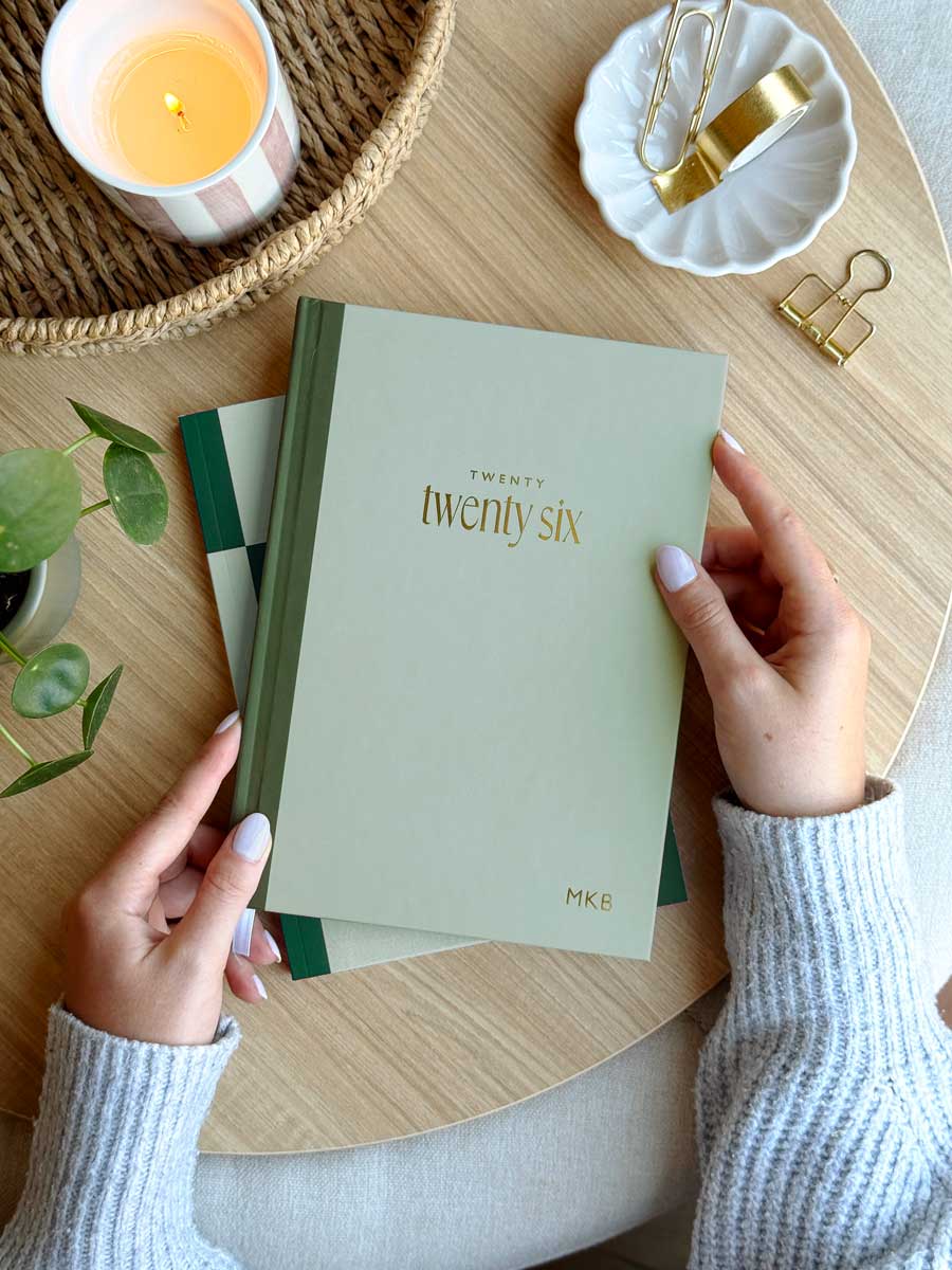 woman holding 2026 week to view diary with sage green hardback cover with gold foiled personalised name