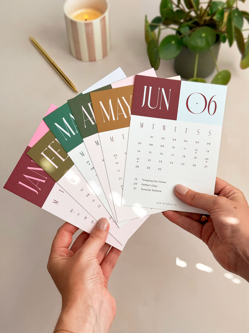 hands holding all 12 months of 2027 monthly calendar card refill pack in bold colour block design. Cards are a6 sized and feature key occasions & UK bank holidays.