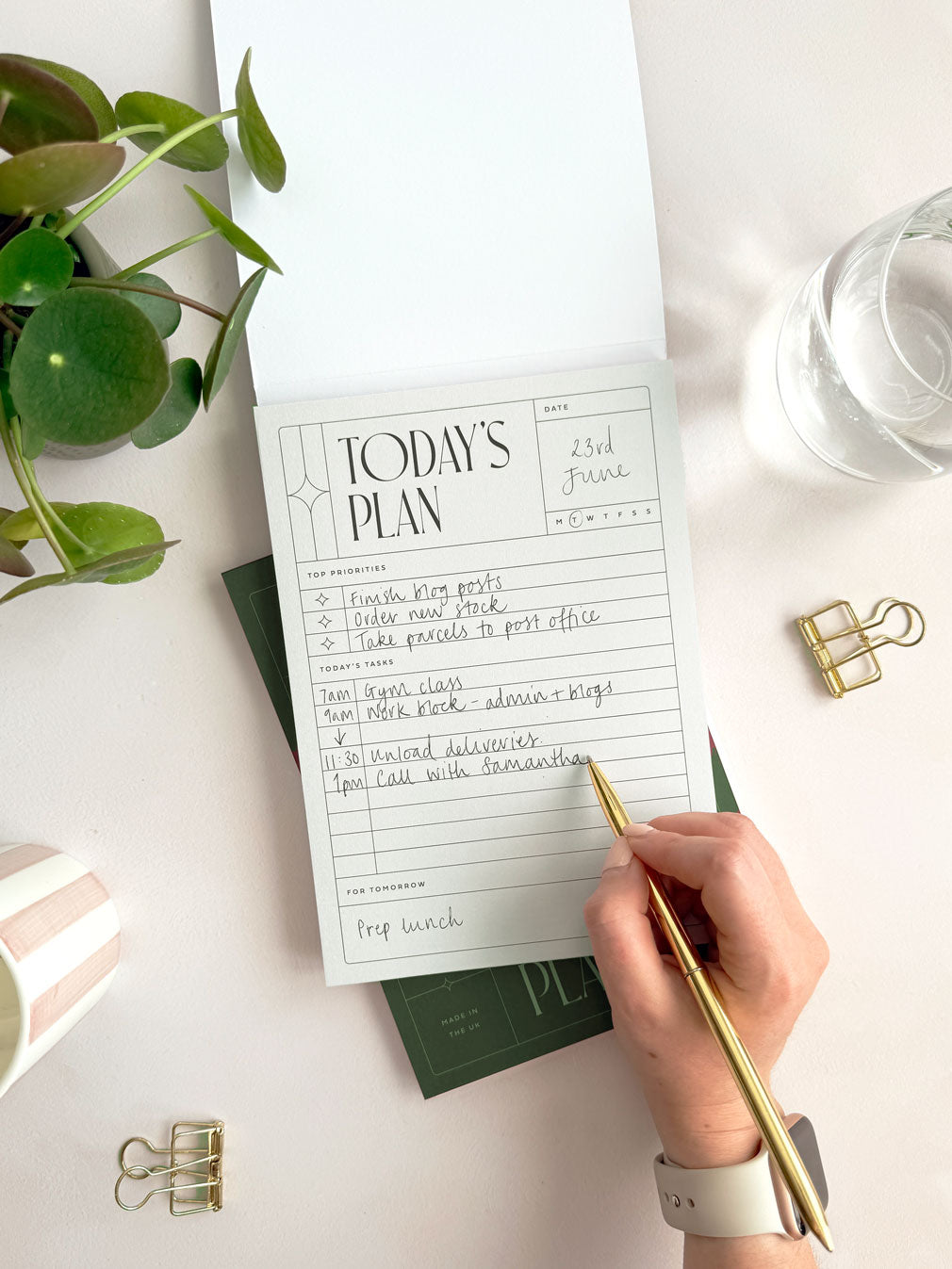 flat-lay view of a woman writing in daily plans on a &